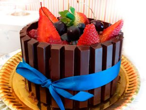 Bolo dos Pais: bolo de chocolate, mousse de chocolate 60% cacau, envolto por barrinhas de Kit Kat e coberto com frutas vermelhas.